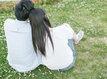 芝生の上で寄り添うカップル